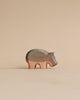 A Handmade Holzwald Small Hippo wooden figurine standing against a beige background, showcasing natural wood grain and a smooth finish.