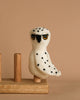 A Snowy Owl Finger Puppet, evocative of the handmade wool creations by Nepal artisans, perched gracefully on a wooden stand.