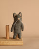 A Felt Gray Cat Finger Puppet perched delicately on a wooden stand.