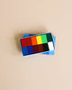 A set of colorful square Stockmar Wax Block Crayons Box -12 Assorted arranged in a blue holder against a light beige background, featuring a range of colors including red, blue, green, and yellow.