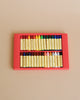 A box of thirty-two assorted Stockmar Wax Stick Crayons, arranged neatly in their packaging, displayed on a plain beige background.