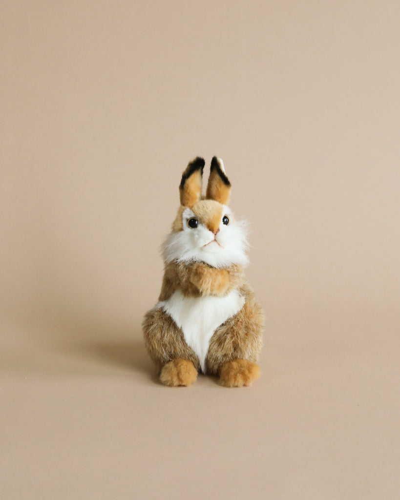 A high-quality Thumper Rabbit Stuffed Animal with a brown and white fur pattern sits against a plain beige background. The toy has prominent blue eyes and tufted ears.