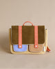 A stylish vertical messenger bag featuring a Corduroy Pear Jam body with blue and cream panels, and orange waterproof nylon straps with pink squares, standing against a light beige background.