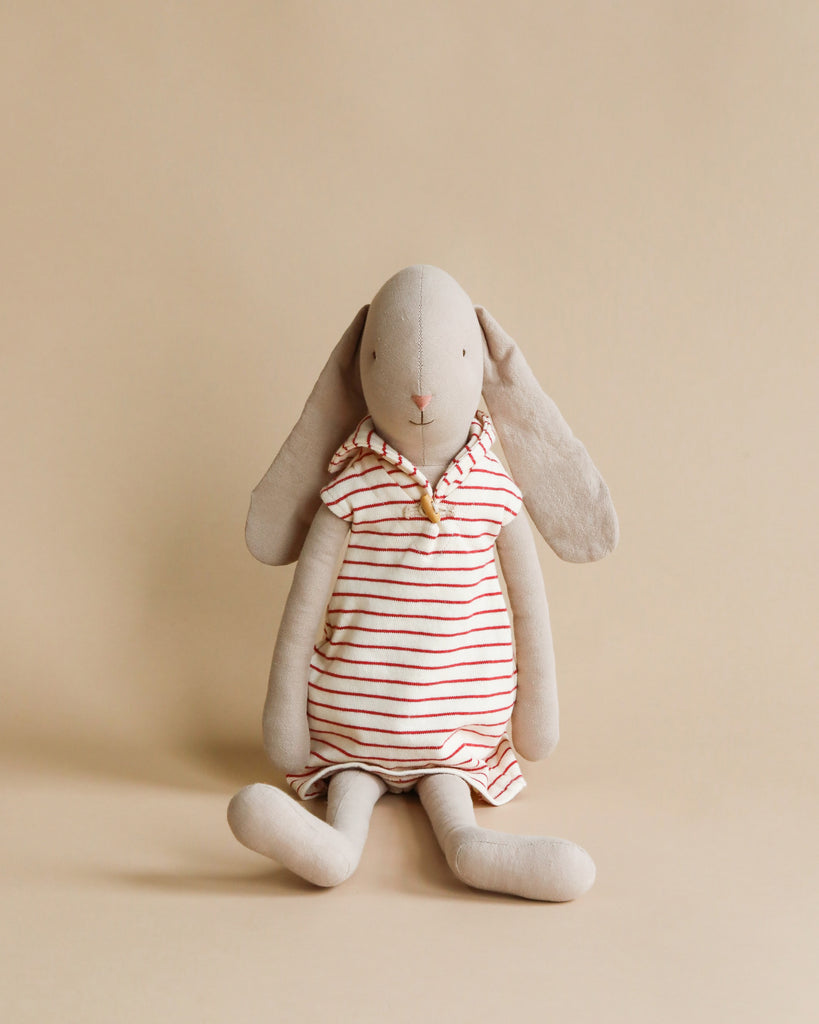 The Maileg Bunny Size 4, wearing a red and white sailor dress, sits against a plain beige background, ready for its next adventure.