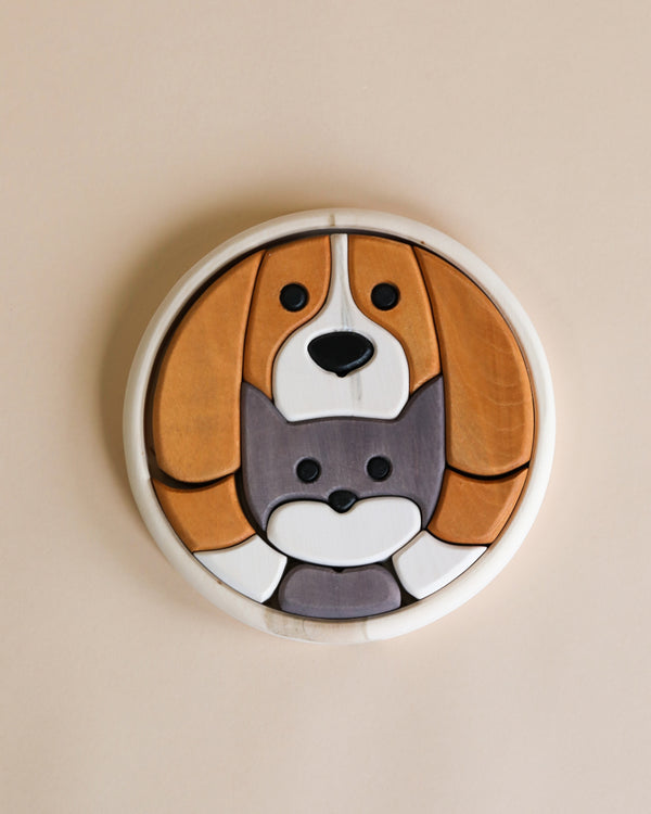 A Round Cat and Dog Puzzle features a cute dog and cat design, handmade with natural wood markings. The dog has brown and white non-toxic paint markings, while the cat is primarily gray. The puzzle pieces are arranged neatly within a circular frame on a beige background.