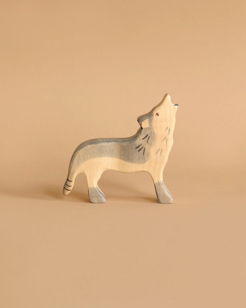 A Holztiger Wolf, Howling figurine from HOLZTIGER figures stands on a beige background. The wolf has a minimalist design with muted colors and is depicted howling, with its head tilted upward and mouth open. Made in Europe, this piece showcases the true artistry of handcrafted wood.