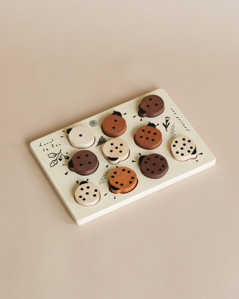 A variety of Wooden Tray Puzzles - Count to 10 Ladybugs with different designs and topping styles are neatly arranged on a rectangular ceramic plate against a beige background.