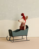 The Maileg Christmas Sleigh - Green showcases a small toy mouse with hand-painted details, wearing a red hat and scarf, sitting on the dark green sled against a simple winter backdrop.