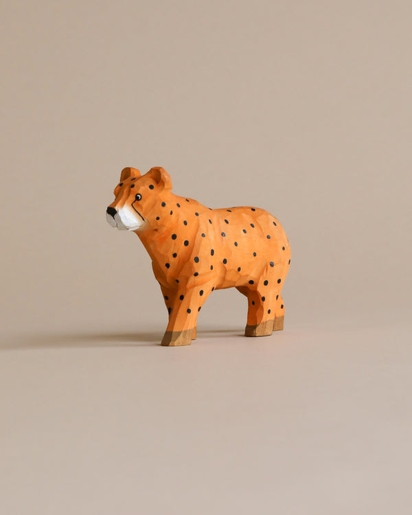 A Hand Carved Wooden Cheetah model, with a lifelike stance and detailed painting, ideal for kids' bedroom decor, positioned against a neutral beige background.