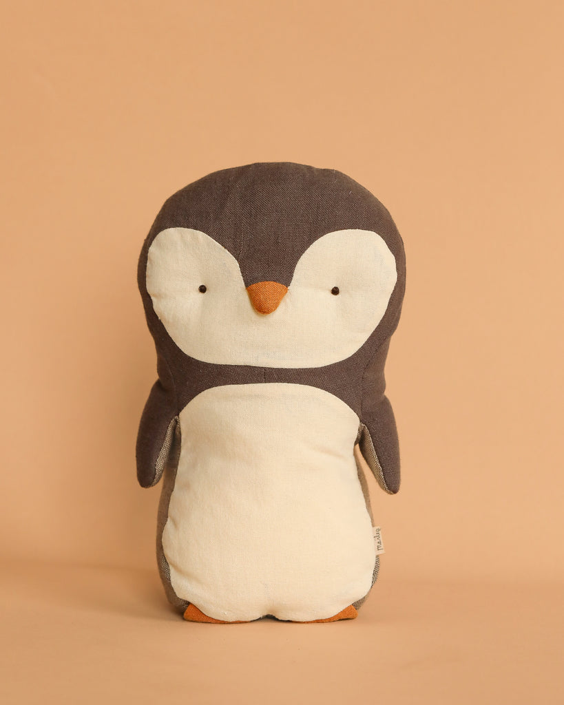 Introducing the Maileg Penguin Stuffed Animal - Small, a gentle companion crafted from soft, plush materials. This adorable penguin features a charming white belly and dark grey head and wings, standing upright against a plain beige background. It's perfect for all ages.