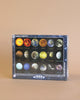 A NASA, The Solar System - 1000 Pieces puzzle from puzzle company featuring planets, moons, and celestial bodies of our solar system displayed against an orange background.