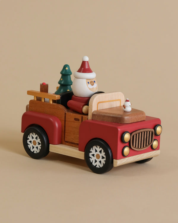 A Santa-mobile Music Box, crafted from premium hardwoods and painted in red and brown, features a snowman driver, a Christmas tree, and gifts, set against a beige background.