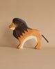 A wooden lion, part of the "Noah's Ark With Animals" set, features a dark brown mane, light brown body, and black tail. It's crafted from solid wood with simple stylized facial features, standing on a neutral background.