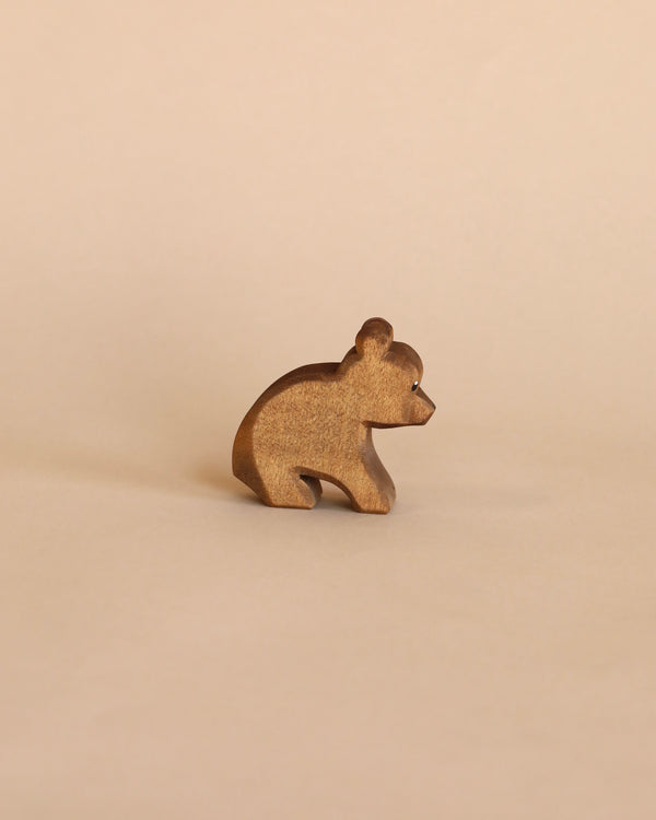 A Ostheimer Small Bear - Sitting on a plain beige background, with visible wood grain and a simplistic, stylized design.