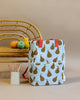 A stylish Sticky Lemon Backpack Large | Farmhouse | Special Edition Pear Jeans with red handles and a YKK zipper, placed next to a wooden chair with a yellow duck, orange toy, and crayons on a beige background