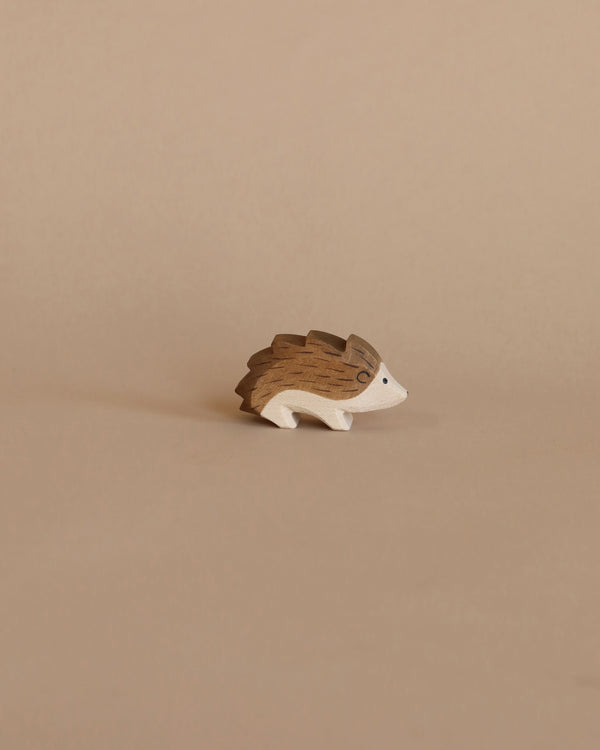 A handcrafted Ostheimer Hedgehog figurine on a plain beige background, featuring intricate grain patterns and carved details.