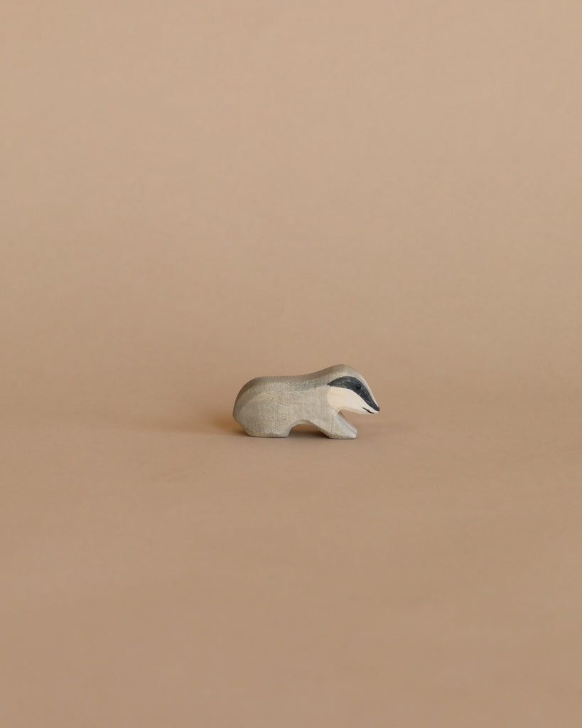 A small, minimalist Ostheimer Badger figurine on a plain beige background.