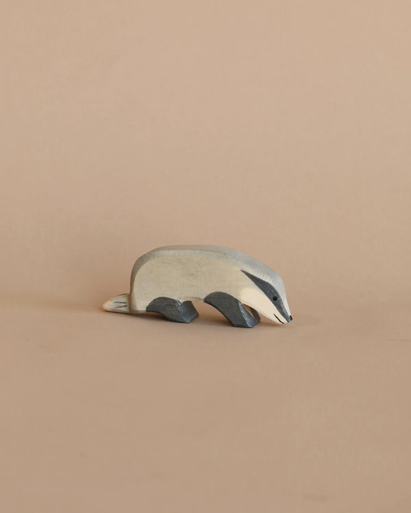 A small metal Ostheimer Badger - Head Down figurine with a handcrafted design and brushed finish on a plain beige background.