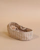 A Maileg Carry Cot, Large - Sand, with a charming floral pattern sits on a neutral background, resembling a quaint portable bed. It holds a soft, fuzzy brown teddy bear.