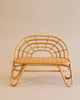 The Kid’s Rattan Bench features an intricate, curved backrest and a woven seat with a natural wood finish. The bench boasts a minimalist design, standing on four looping legs that blend traditional and contemporary styles harmoniously. As part of the basket furniture series, it complements neutral beige backgrounds perfectly.