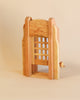 A wooden Ostheimer Portcullis with a lattice backrest, crafted from sustainably sourced materials, exhibiting a modern design and smooth finish, on a beige background.