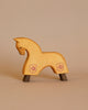 The Ostheimer Yellow Horse for Knight is a small, handcrafted wooden figurine featuring a natural finish. This minimalist horse showcases two subtle pink flower designs on its body and stands sturdily on four dark wooden legs, set against a plain beige background. Made from sustainably sourced materials, it is ideal for imaginative play.