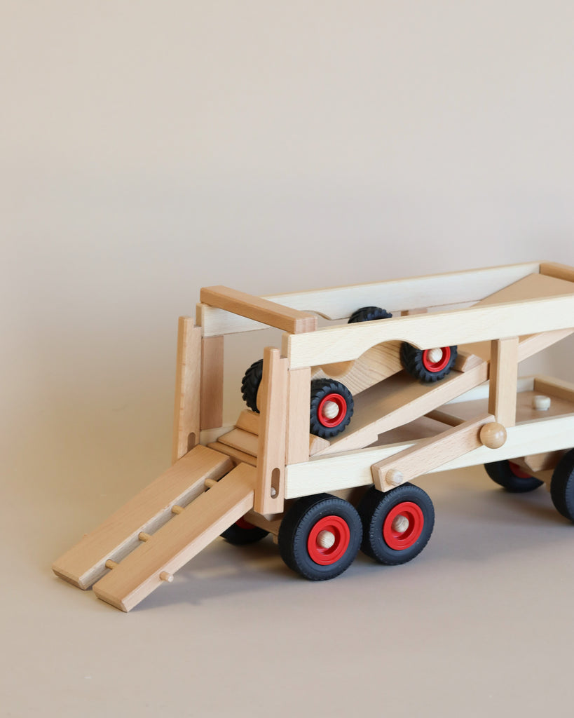 A Fagus Car Transporter with a ramp extended, showcasing four wheels in red and black colors on a neutral background.