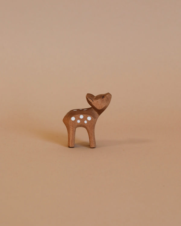 Small, brown Ostheimer Deer - Small Head High figurine with white spots on its back, standing on a plain beige background. This handcrafted wooden toy deer is looking upwards with its ears perked, perfect for imaginative play and reminiscent of Ostheimer toys.