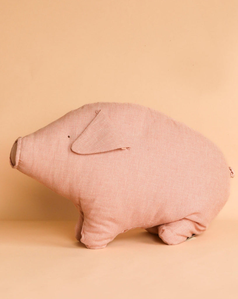 A soft fabric pig plush toy is set against a plain beige background. The Maileg Polly Pork, Large is simple in design with minimal details, featuring basic stitched eyes and a small fabric ear, capturing a cute and minimalist aesthetic that invites a warm hug.