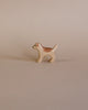 A small, high-quality Handmade Holzwald Golden Retriever Puppy figurine, with a light brown and white coat, standing on a plain beige background.