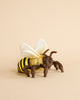 A Honey Bee Stuffed Animal with yellow and black stripes and white wings, placed against a beige background. The bee, part of our hand sewn animals collection, has brown legs and antennae, and a soft, fuzzy texture, giving it a cute and cuddly appearance.