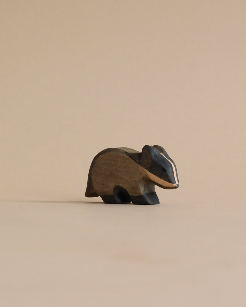 A Handmade Holzwald Badger, presented in a minimalist style, placed against a plain beige background and crafted from materials used in sustainable toys.