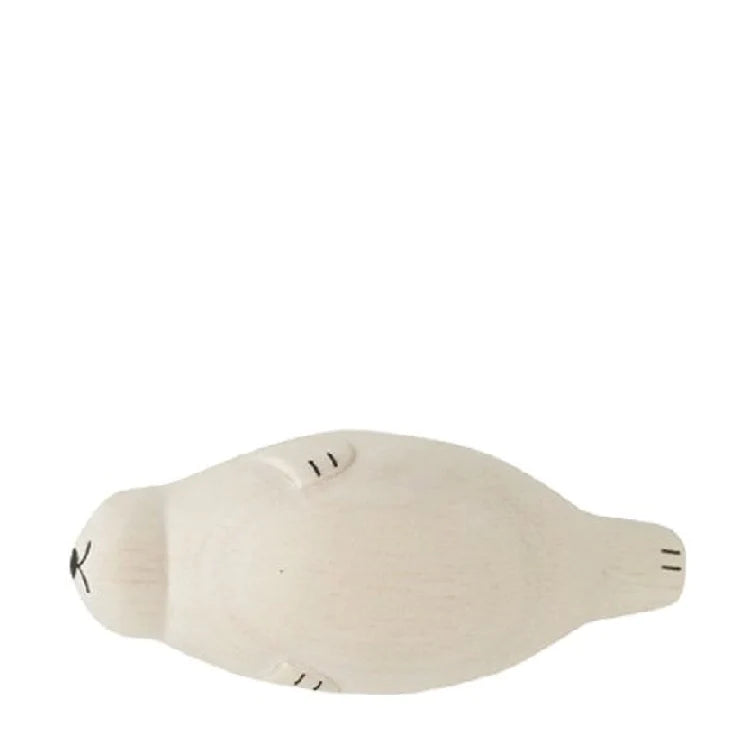 The Handmade Tiny Wooden Seal is hand-carved with care and captures a smooth, white seal lying on its stomach. This unique decoration features simple black lines for the eyes, nose, and whiskers, with subtly defined flippers also illustrated in short black lines. The background is plain white.