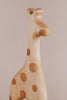 Introducing the Handmade Wooden Giraffe Pull Toy: a beautifully crafted giraffe figurine made from smooth, light wood. This minimalist design features darker circular spots on its body, defined curves, and is set against a plain background, making it an appealing addition to any child's toy collection.