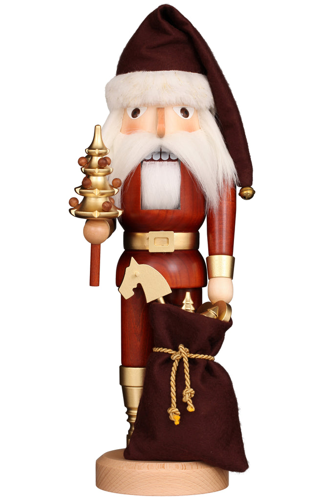 This exclusive Christian Ulbricht collectible wooden nutcracker, known as the Natural and Gold Santa, is dressed in a striking red and gold uniform and crowned with a brown hat. It stands on a light wooden base while holding a small golden tree in one hand and a brown sack with rope ties in the other, featuring an impressive white beard and mustache.