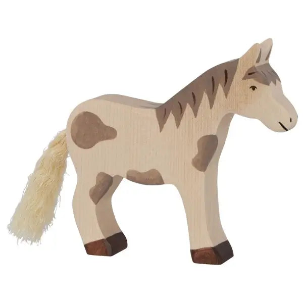 A handcrafted Holztiger Horse, Mustang from the high quality HOLZTIGER figures collection features a neutral beige color with darker brown spots on its body and mane. Made in Europe, the horse has a tassel-like tail and a simple, stylized design, capturing a charming and rustic aesthetic.