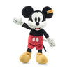 A Steiff, Disney's Mickey Mouse Stuffed Plush Toy, 12 Inches from the Disney Originals collection, this toy showcases Steiff craftsmanship with its iconic features: large round ears, white gloves, red shorts with white buttons, yellow shoes, and a cheerful expression with one arm raised.