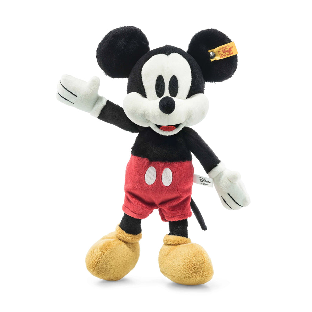 A Steiff, Disney's Mickey Mouse Stuffed Plush Toy, 12 Inches from the Disney Originals collection, this toy showcases Steiff craftsmanship with its iconic features: large round ears, white gloves, red shorts with white buttons, yellow shoes, and a cheerful expression with one arm raised.