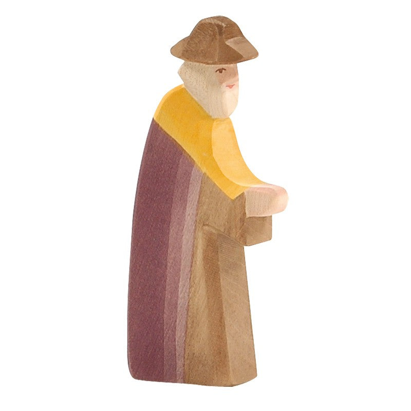 This Ostheimer Joseph - Walking, a handcrafted wooden figurine of a bearded man, features a profile view as he wears a brown hat and a cloak with yellow, purple, and brown stripes. Perfect for imaginative play, it embodies the timeless charm of Ostheimer toys.