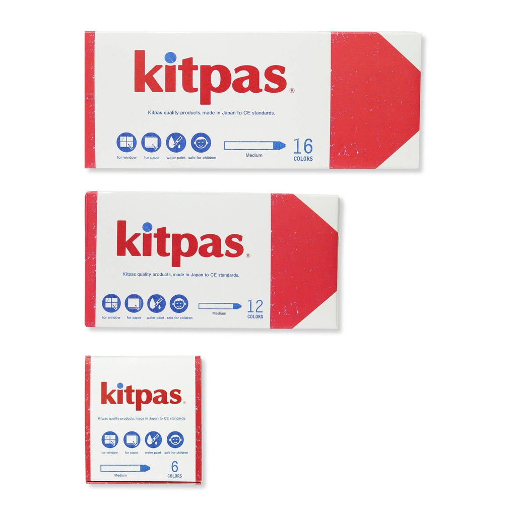 Three boxes of Kitpas products are displayed, featuring Kitpas Crayons in three different color sets: one with 16 colors, another with 12 colors, and the Kitpas Crayons - 6 Colors set. These non-toxic crayons come in white boxes accented with red and display icons indicating their various uses, making them ideal for watercolor painting enthusiasts.