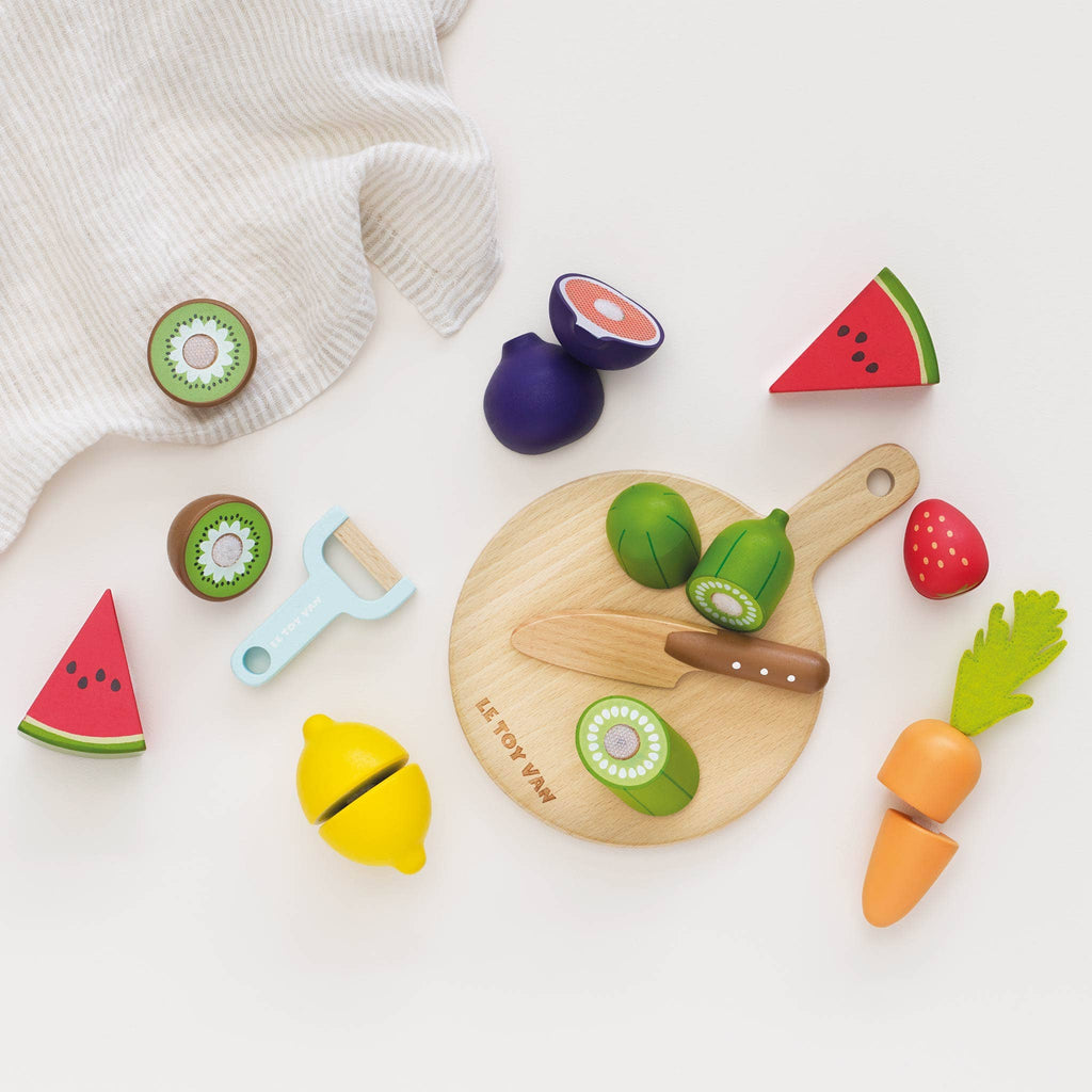 The Wooden Chopping Board & Sliceable Play Food set offers a lively and colorful collection of wooden toy fruits and vegetables such as kiwi, watermelon, and carrot. Ideal for role play, it comes with a toy knife designed to enhance fine motor skills. Set against a white background with a nearby striped cloth, this playset is perfect for sparking imaginative play.