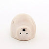 A small, rounded, beige wooden figurine of a seal with a simple, minimalist design. This one-of-a-kind decoration features black dots for eyes and nose, and subtle lines for ears and other features. It sits on a plain white background.