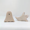 Two Wooden Standing Ghosts, crafted from sustainable hardwood, are showcased against a plain background. The ghost on the left stands upright with a surprised expression, while the ghost on the right leans to one side, smiling playfully with its curved body.