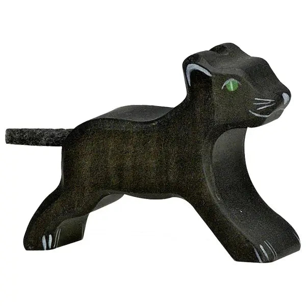 A handcrafted wood figurine of a black panther with a simple, stylized design. Made in Europe by HOLZTIGER figures, the Holztiger Panther, Small has bright green eyes, white markings on its face and legs, and a textured tail. The figure is depicted in a graceful walking pose.