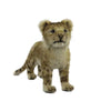 A Lion Cub Standing Stuffed Animal, meticulously hand sewn. The toy has light brown fur with darker brown spots, rounded ears, and a slightly open mouth, giving it a lifelike appearance. The backdrop is plain white.