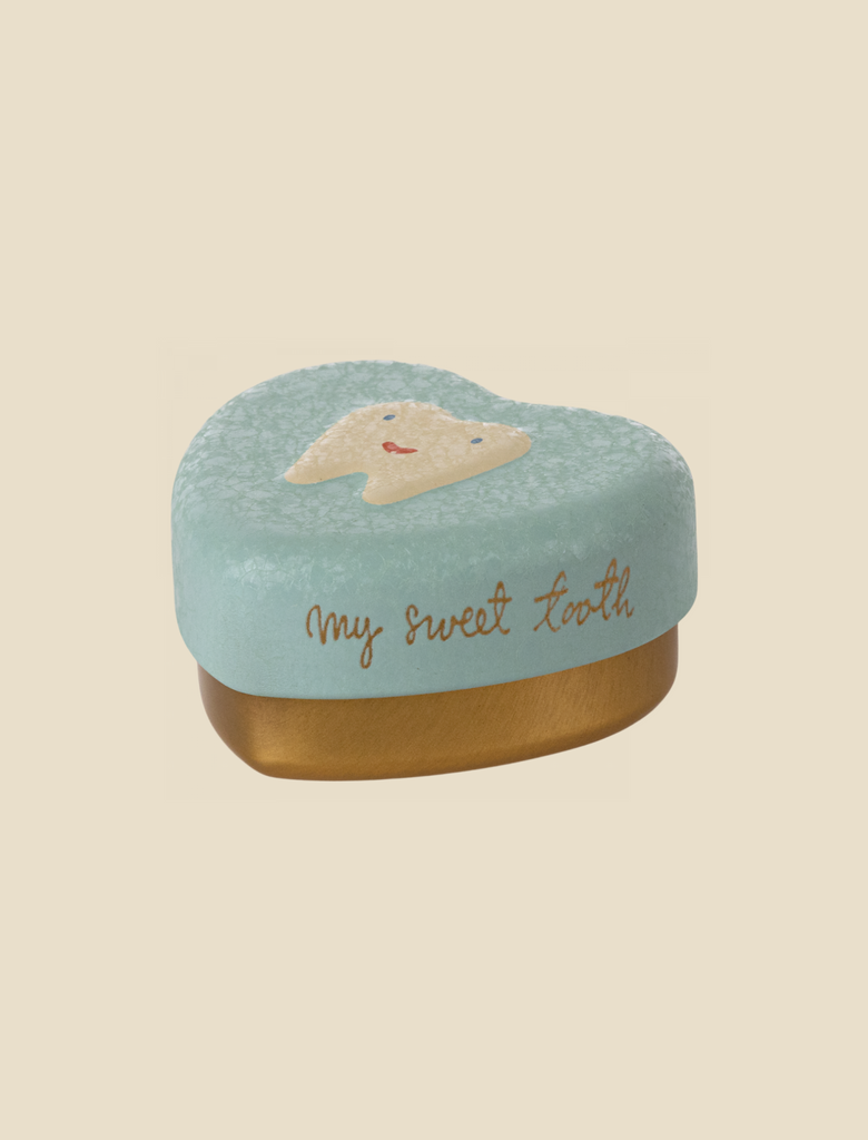 A small, heart-shaped Maileg Tooth Box with a light blue lid featuring a smiling tooth illustration and the text "my sweet tooth" written in gold. The base of the box is golden, perfect for preserving childhood memories or storing baby teeth.