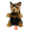 A Yorkie Terrier Dog Puppet from the HANSA animals collection is shown. The puppet has soft, fluffy fur in shades of tan and black, with large ears and realistic detailing. A hand is visible inside the puppet, holding it upright.