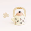 The Vintage Wooden Role Play Kettle is a delightful toy teapot featuring an eco-friendly, FSC certified wooden handle and a pink lid, beautifully decorated with black and orange flowers. A small cloud shape adds to its appeal against a plain white background.