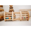 Wooden Rain Maker with multicolored balls inside, placed on its side on a light-colored surface. Made from non-toxic materials, the background shows various wooden toys and blocks, creating a cozy and natural play environment.