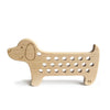 A Maple Wood Lacing Toy - Rex the Dog with a smooth finish and engraved facial features. The body features two rows of evenly spaced holes for threading cotton laces. Designed in a simplistic, playful style, this wooden toy is perfect for children.